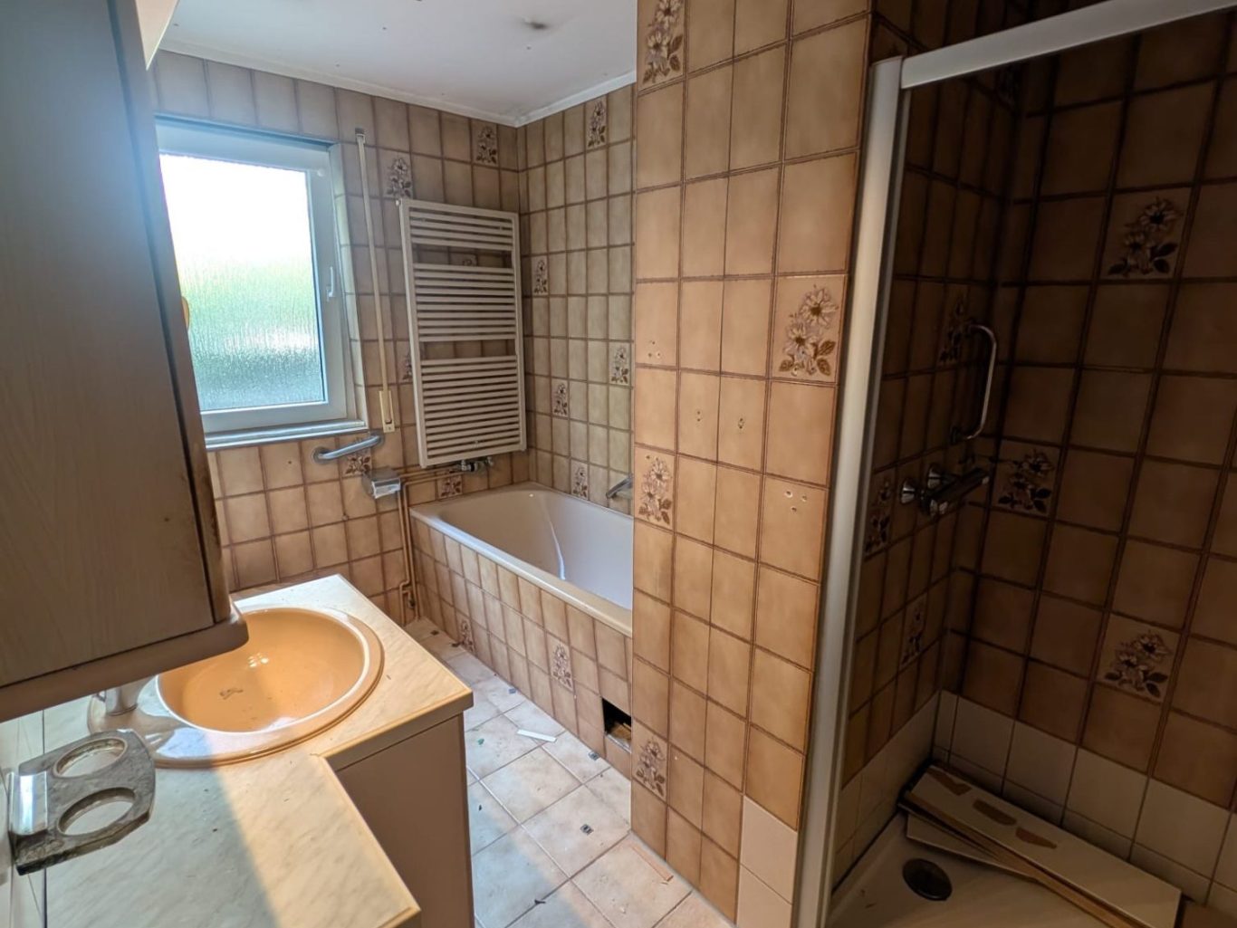 Kleines Badezimmer mit Waschbecken, WC und hellblauen Fliesen.