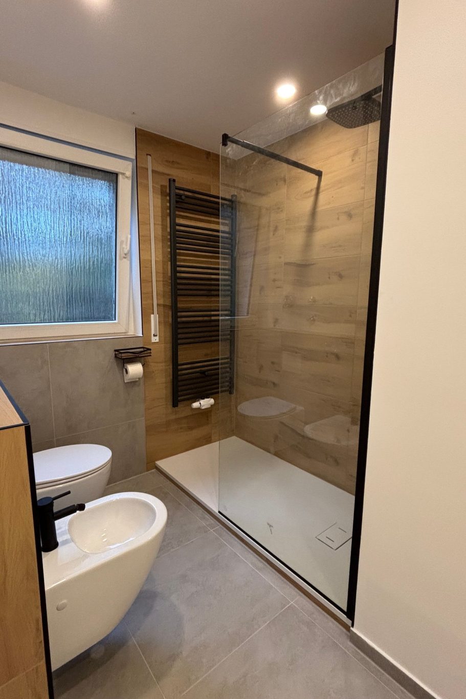 Modernes Badezimmer mit Dusche, Waschbecken und WC im Industrial Style.